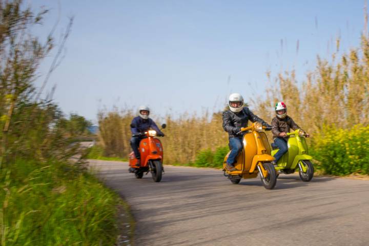 three men driving scooter trough Mallorca