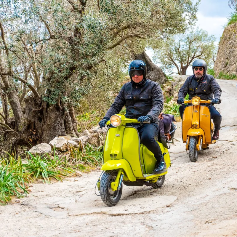 a person riding a motorcycle down a dirt road