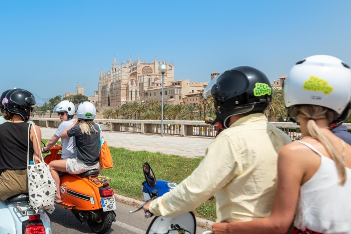 a group of people riding on the back of a motorcycle