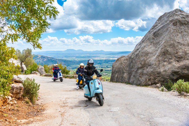 a man riding a motorcycle down a dirt road