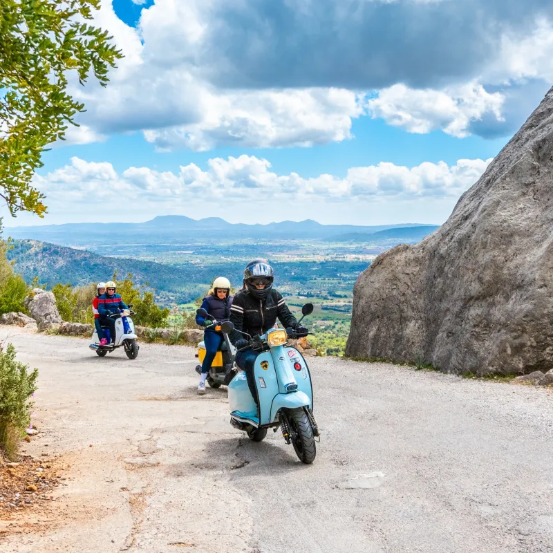 a man riding a motorcycle down a dirt road