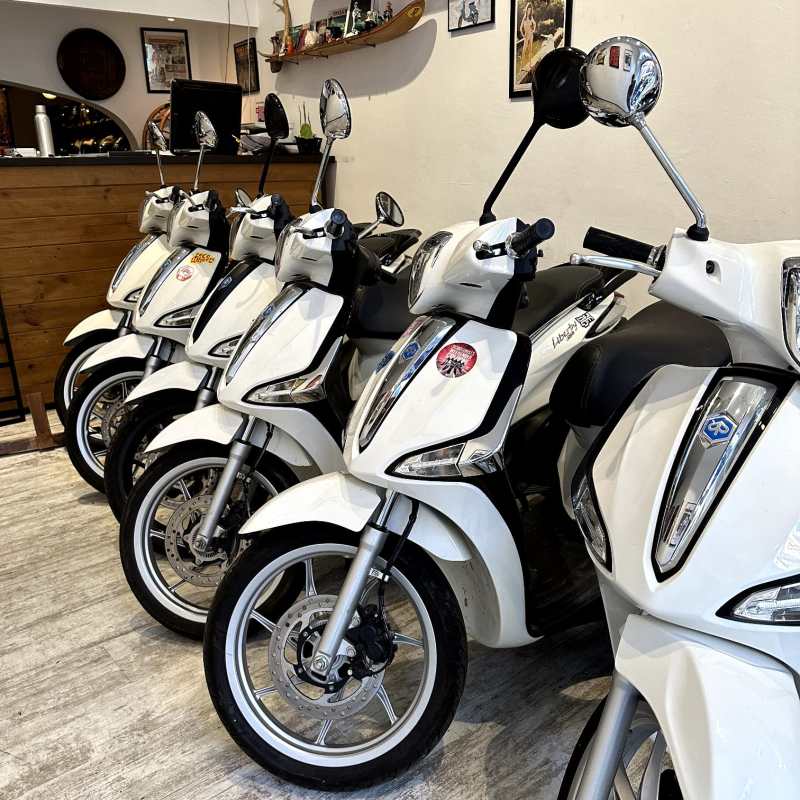 a row of parked motorcycles sitting on the side of a building